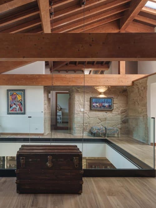 Salón con vigas de madera y suelo de parquet realizado por Parquets Blanco en Vigo